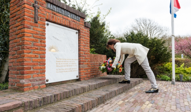 <p>Voorzitter van Parel aan Zee, Marieke Sibarani, legt een bloemstuk neer bij het oorlogsmonument</p>