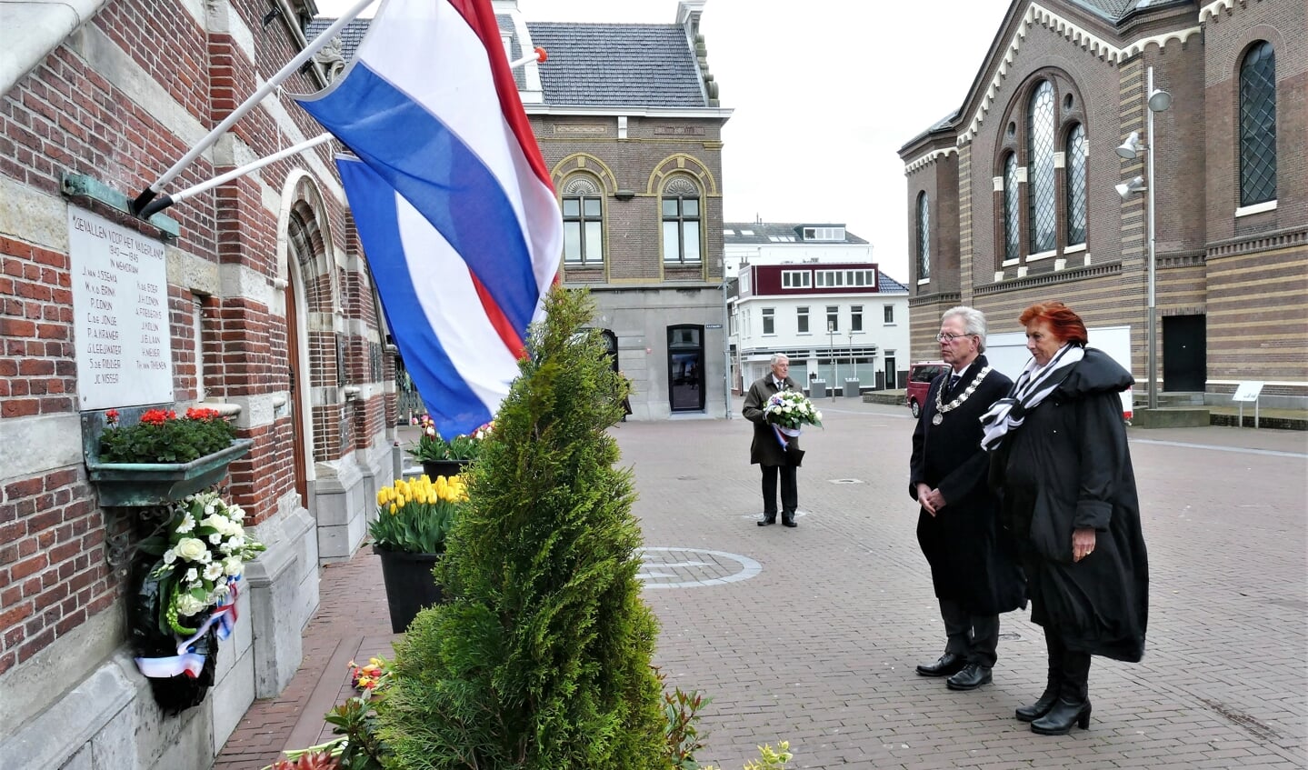 Don Bijl, zijn vrouw en op de achtergrond Dick Blokker houden stil bij het monument op de Kaasmarkt. 