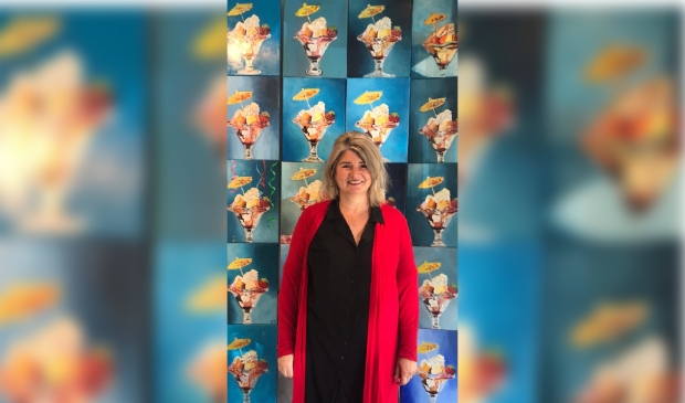 <p>Kunstenaar Jacqueline Hoenselaar voor de wand met ijscoupes. </p>