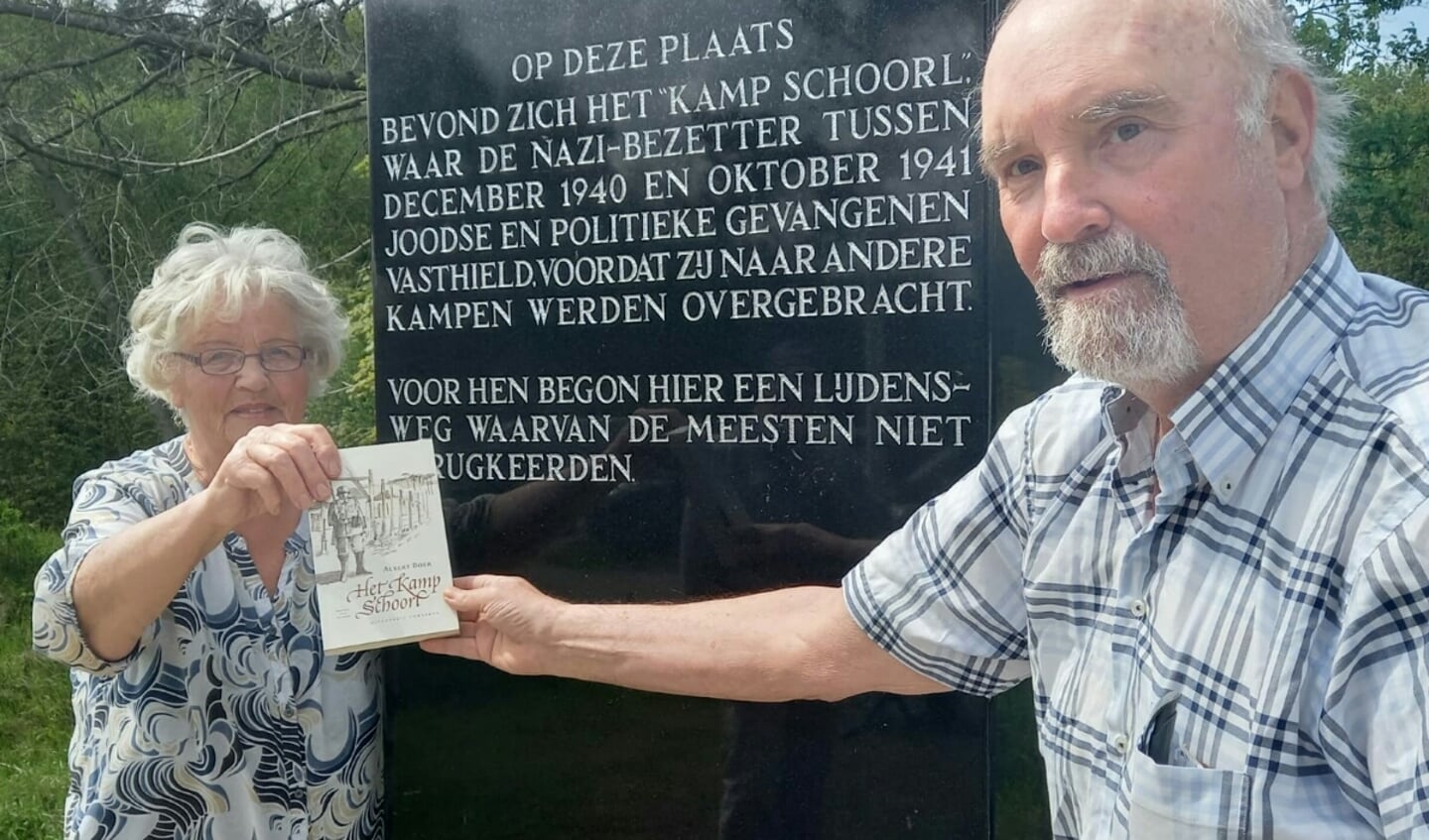 Ela Hulshoff en Wil Janssen met het boek van Albert Boer bij het herdenkingsmonument van Kamp Schoorl