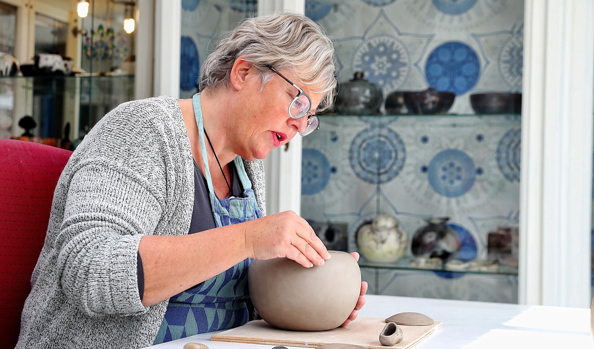 Keramiste Gerdien Noordeloos in haar atelier waar zij werkt aan een urn.