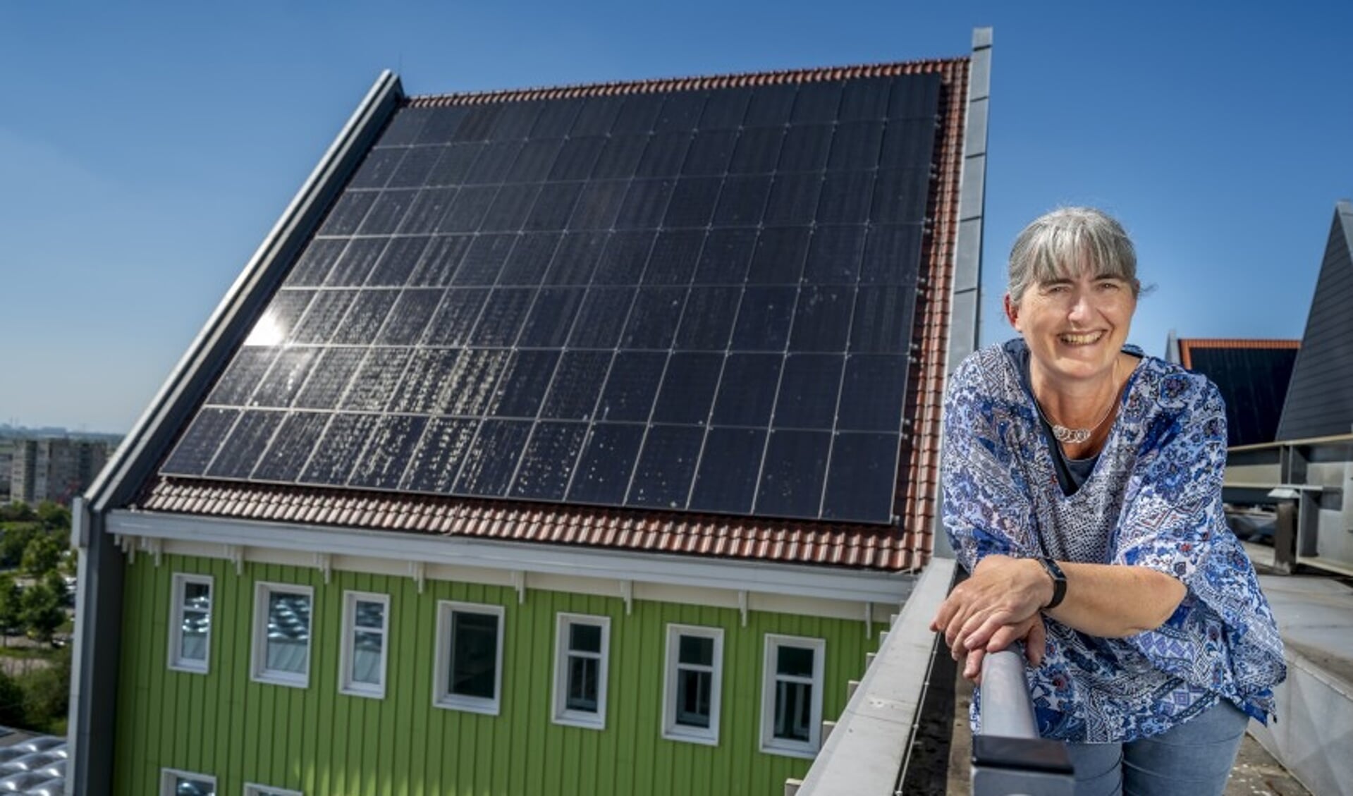 Annette Baerveldt op het dak van het Zaanse stadhuis waar 652 zonnepanelen jaarlijks 156.480 kWh aan elektriciteit opwekken.