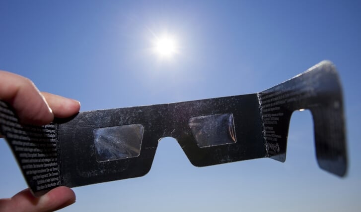 Kijk nooit zonder bescherming naar de zon, maar gebruik een eclipsbril (te koop via internet).