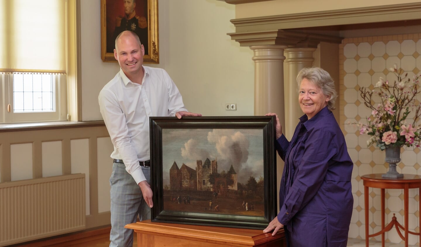 Eric Zwart overhandigt symbolisch het schilderij aan Rina van Rooij.