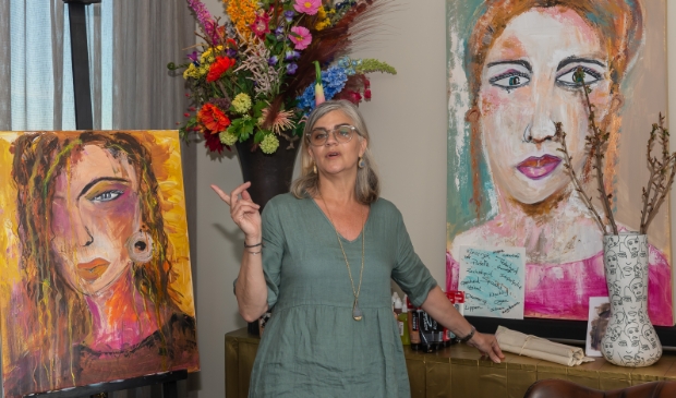 <p>Claudine in haar huisatelier tussen twee vrouwenportretten.</p>