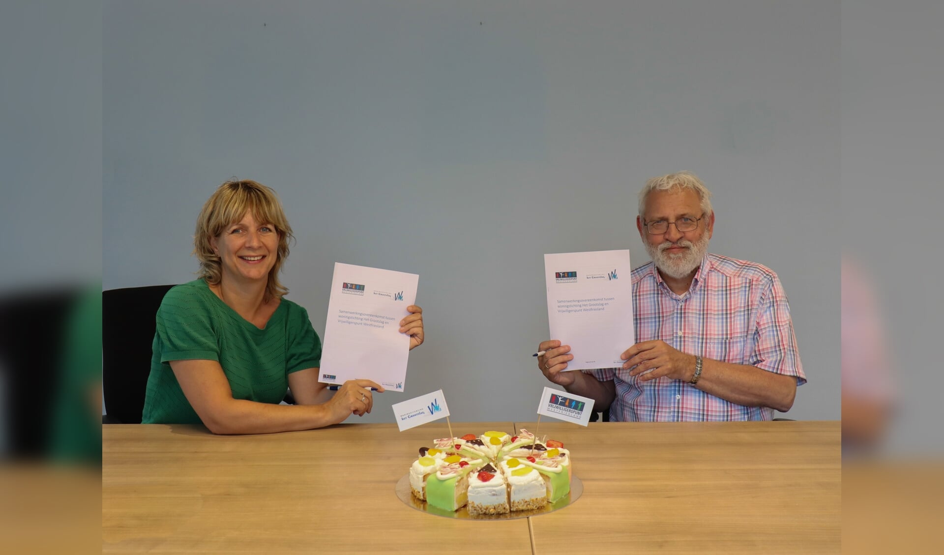 Hans Kröger, directeur-bestuurder van woningstichting Het Grootslag, en Miranda Zwart, directeur-bestuurder van Vrijwilligerspunt Westfriesland, ondertekenen de samenwerkingsovereenkomst. 