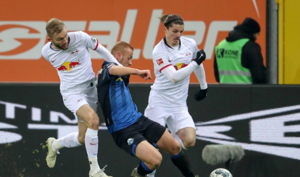 <p>De Leipzig-stieren Konni (r) en Sabi (l) jagen met succes een speler van Paderborn op. </p>