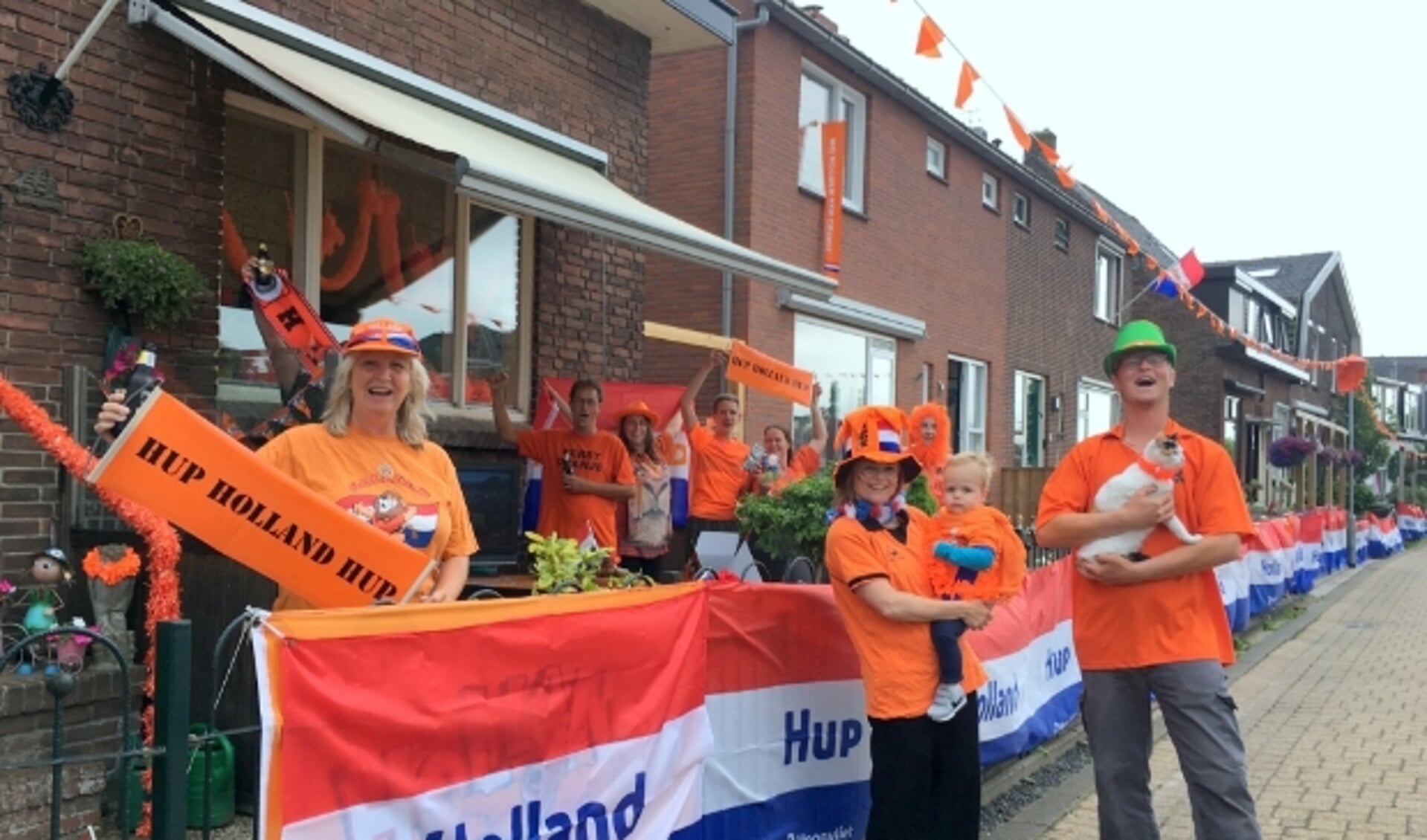 De familie Scholten, met Anneke geheel links, viert het EK met buren. Hun straat, de Ridderbuurt, doet mee met de langste vlag-wedstrijd. 