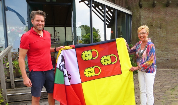 <p>Atze uit Sloten en Jolanda Edema, pr-medewerkster Molen van Sloten, preseteren de nieuwe reuzenvlag die wappert langs de Molen van Sloten.</p>
