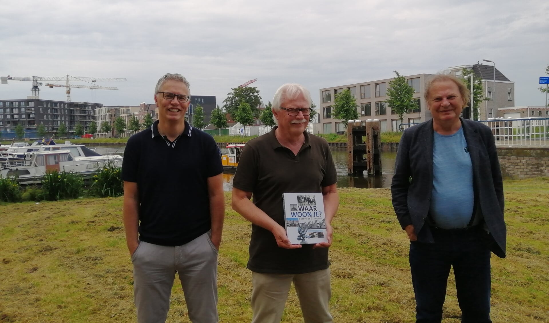 Wouter van Waardt presenteert met trots het jubileumboek, geflankeerd door co-auteurs Yoeri van den Busken (links) en Peter Smit. Op de achtergrond bouwt en groeit Purmerend gewoon door.