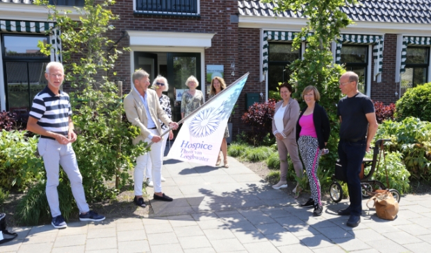 <p>In aanwezigheid van bestuursleden Cees Verkade (l) en Klaas Kwadijk (r), de coördinatoren en de communicatiegroep, bevestigen bestuursvoorzitters Kees Sietsema en Corrie Jaarsma de nieuwe vlag.</p>