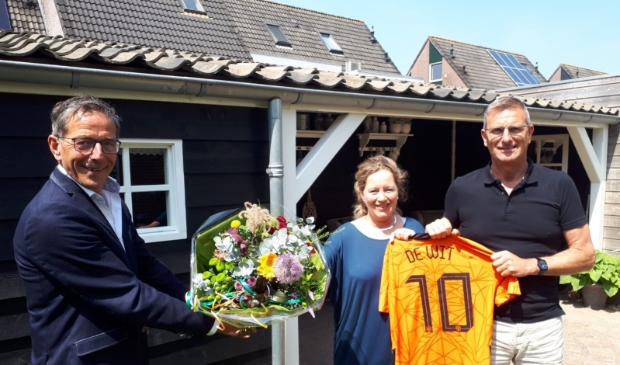 <p>Wethouder Nico Slagter overhandigt een bos bloemen aan de ouders van Dani. </p>