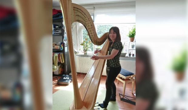 <p>Mirjam begeleidt de zangeres op haar harp.</p>
