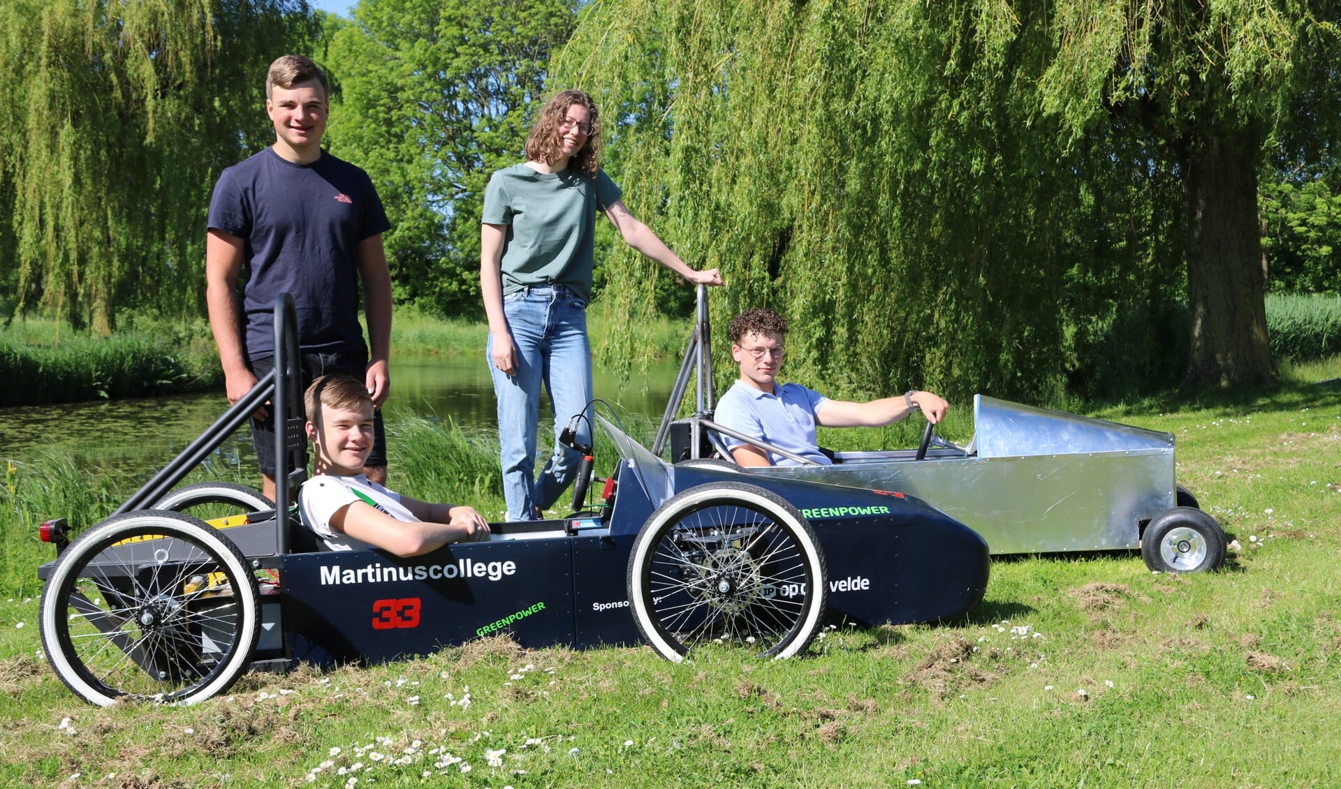 Het Martinus raceteam met de zelfgemaakte auto’s: achter: staand Ariëlle, zittend Etiënne, voor: staand Jasper, zittend Reno.