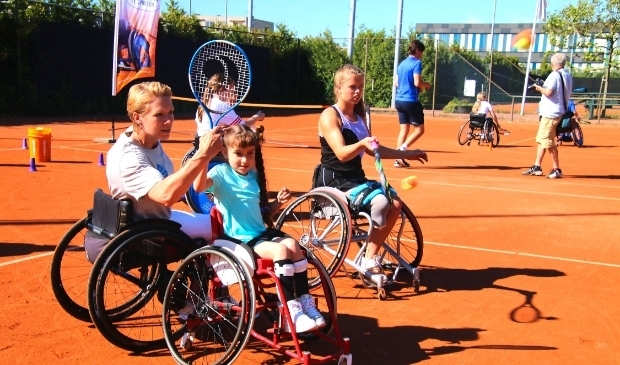 <p>Esther Vergeer helpt de jonge Jasmine met de sport.</p>