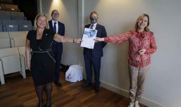 <p>Demissionair minister Cora van Nieuwenhuizen (r) overhandigt het rapport aan Executive Secretary Corinne Mulder.</p><p><br></p><p><br></p>