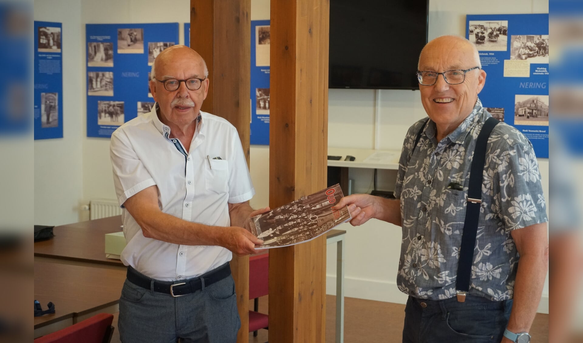 Egbert Ottens (l) ontvangt het kwartaalblad uit handen van de voorzitter van Oud Hoorn, Jaap van der Hout.