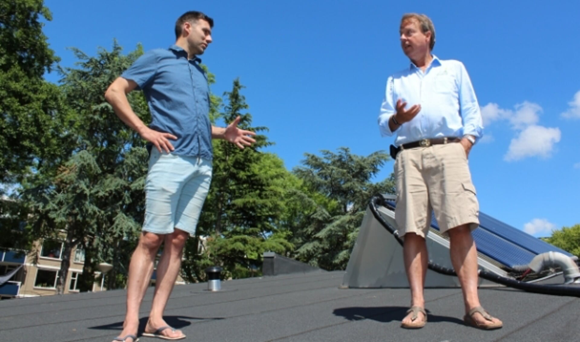 Energiecoaches Robert Vaane (38) en Frank van Oudenhove (63) praten over duurzaamheidstoepassingen, op het dak.