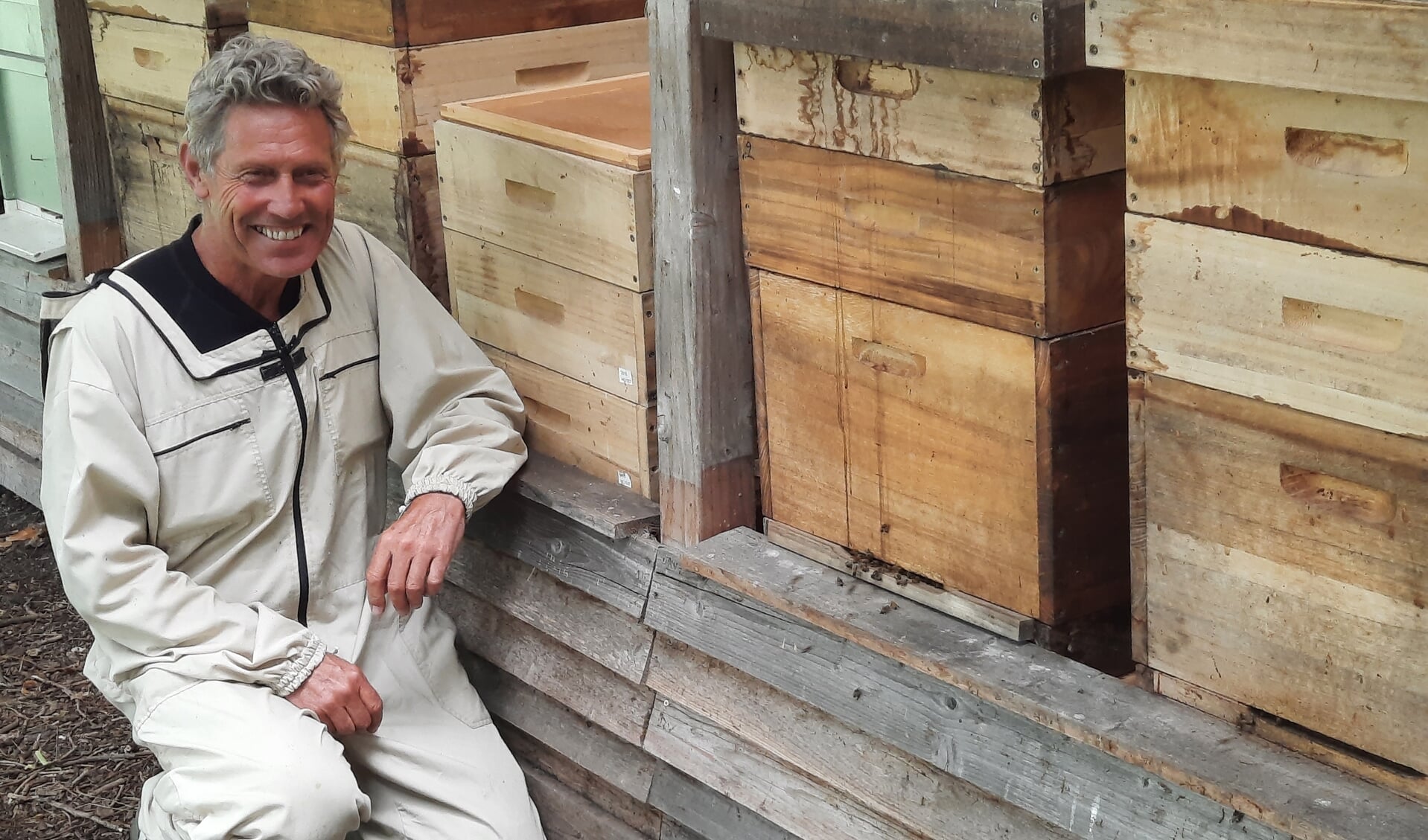 Jan Adrichem in vol ornaat voor de bijenkasten.