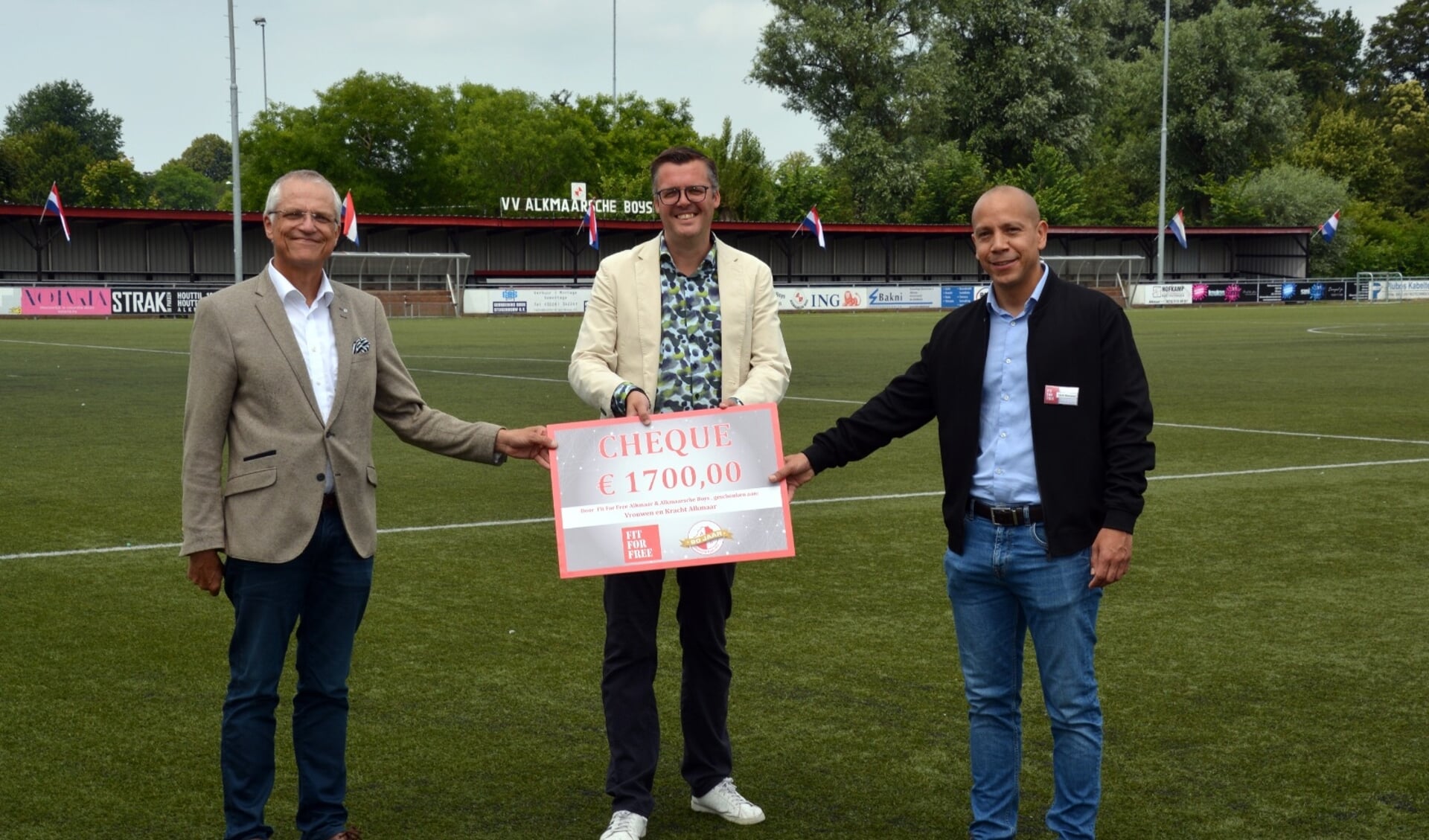Wethouder Pieter Dijkman neemt de cheque in ontvangst van Raoul Guis, locatiemanager Fit for Free en Michiel Kuijpers, voorzitter van Alkmaarsche Boys.