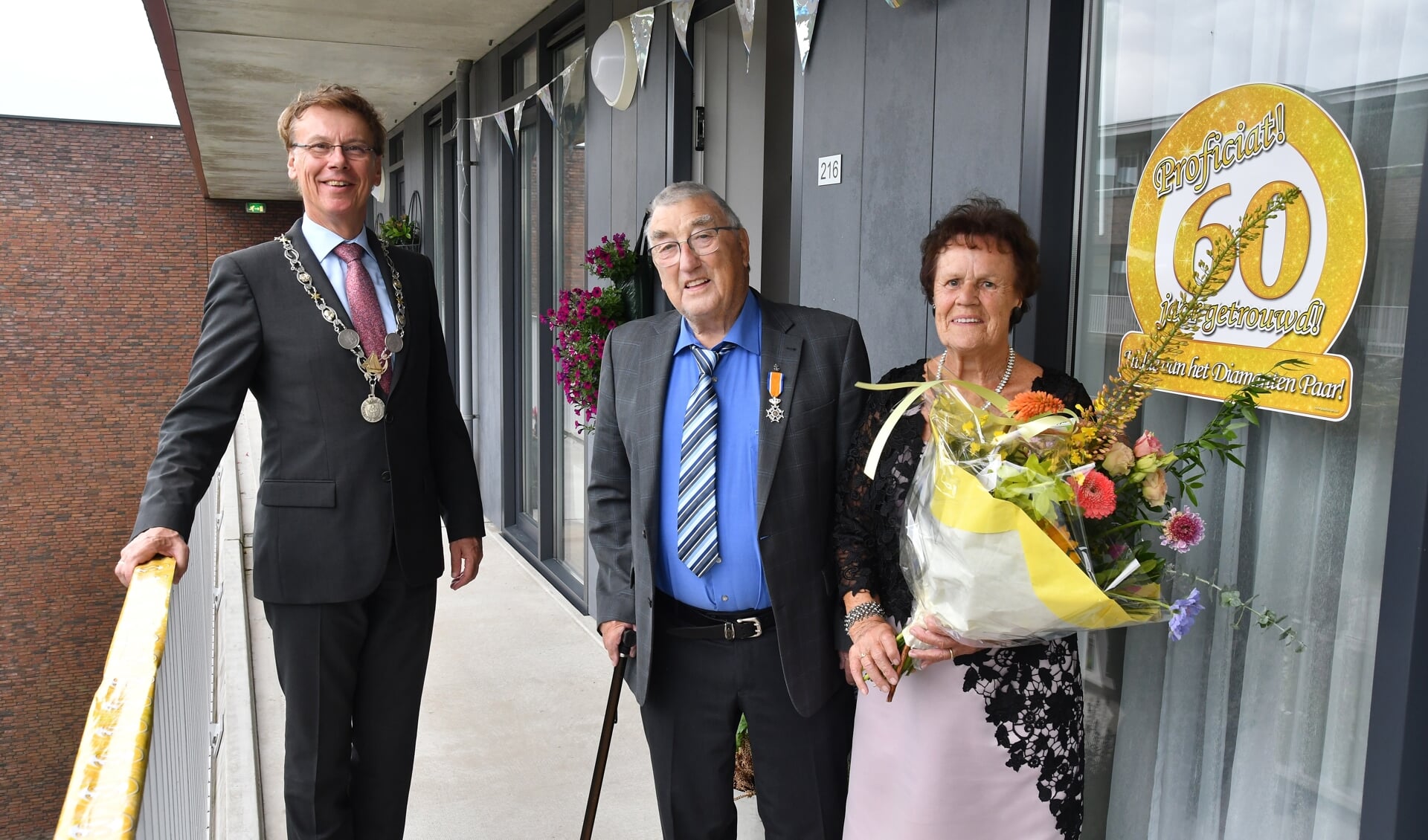 Burgemeester Wortelboer feliciteert het echtpaar Schoon-Brandsen, op gepaste afstand.