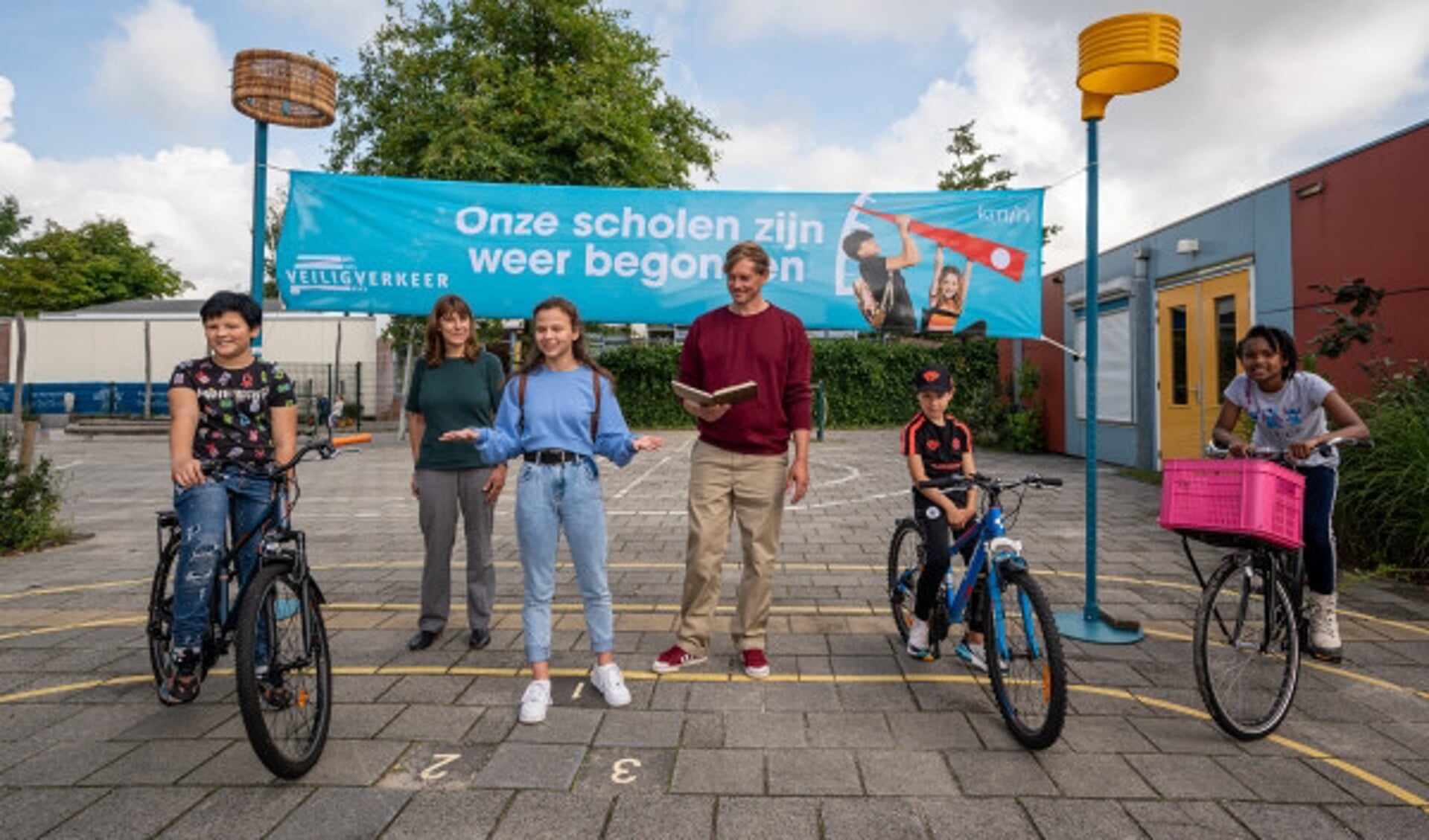 Justin Samgar en scholier Anna dragen het gedicht 'Onze scholen zijn weer begonnen' voor bij basisschool De Golfbreker in Koog aan de Zaan.