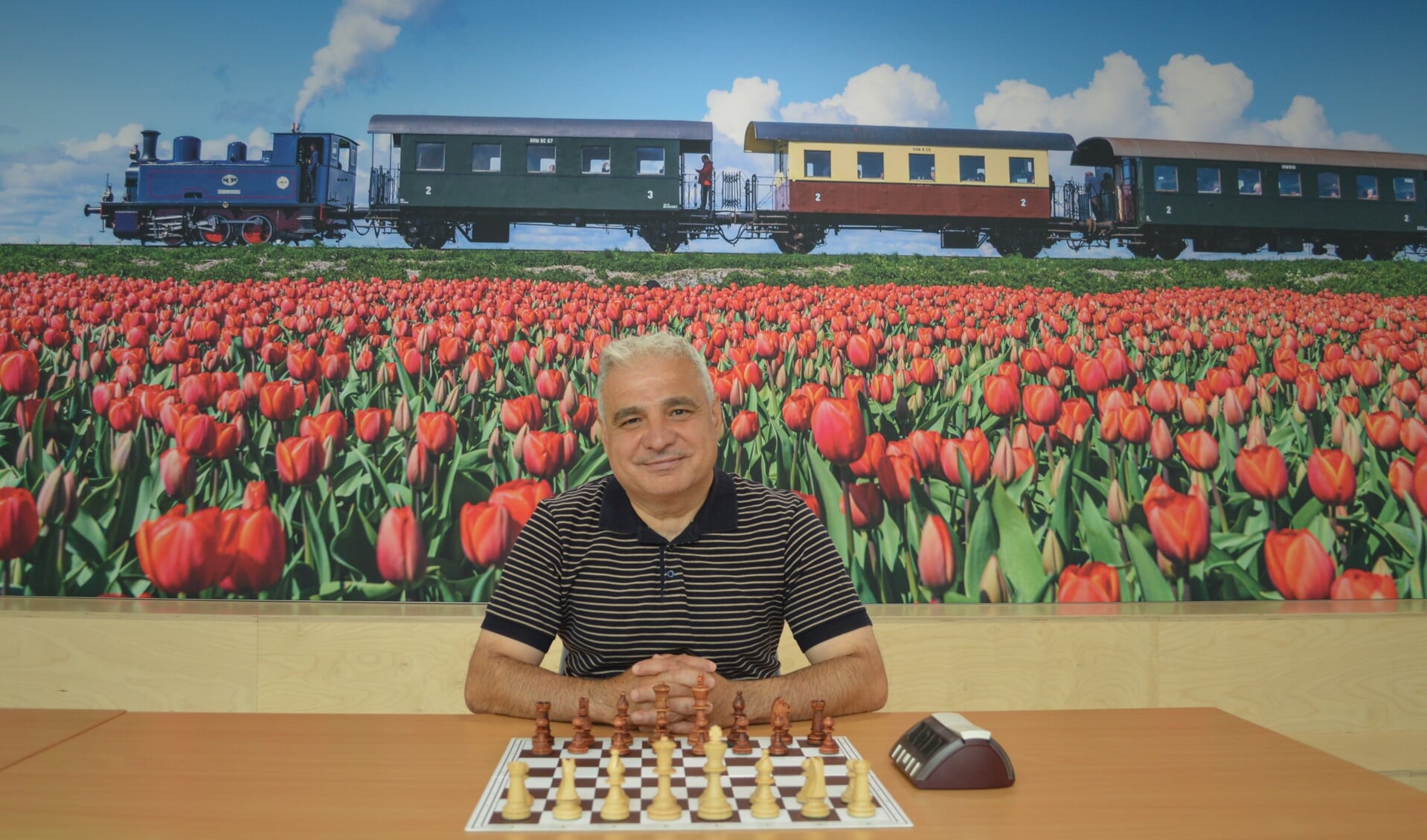 Nizar Alayoubi is in de aula van de Oscar Romero, klaar voor zijn partij in de vierde ronde. Hij schaakt bij een mooi decor: de Hoornse stoomtram. 