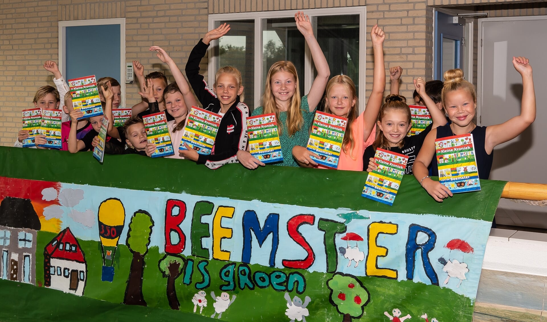 Blije kinderen met de eerste exemplaren van 'De Kleine Kroniek van de Beemster'.