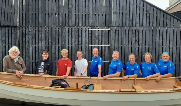 <p>Leerlingen en docenten van Scholen aan Zee met een door henzelf gebouwde St Ayles Skiff. Geheel links Bert van Baar.</p>