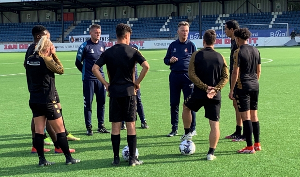 <p>Louis spreekt, de spelers luisteren.</p>