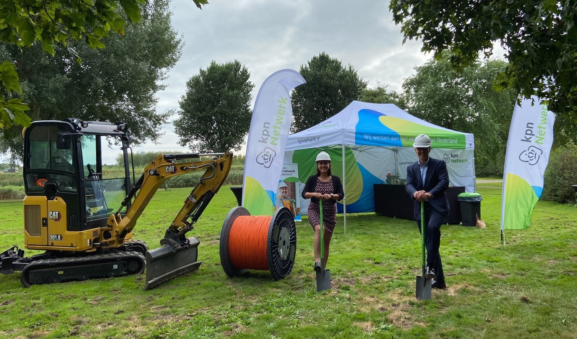 Wethouder Eveline Tijmstra en Willem Offerhaus van KPN steken symbolisch de eerste schop in de grond.