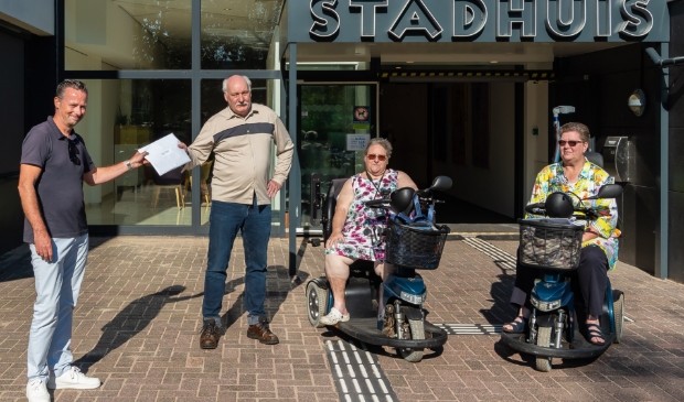 <p>Wethouder Paul van Meekeren neemt van John Elzenaar de petitie in ontvangst. In het midden Dorine Zwang, rechts Linda Horsmeier.</p>