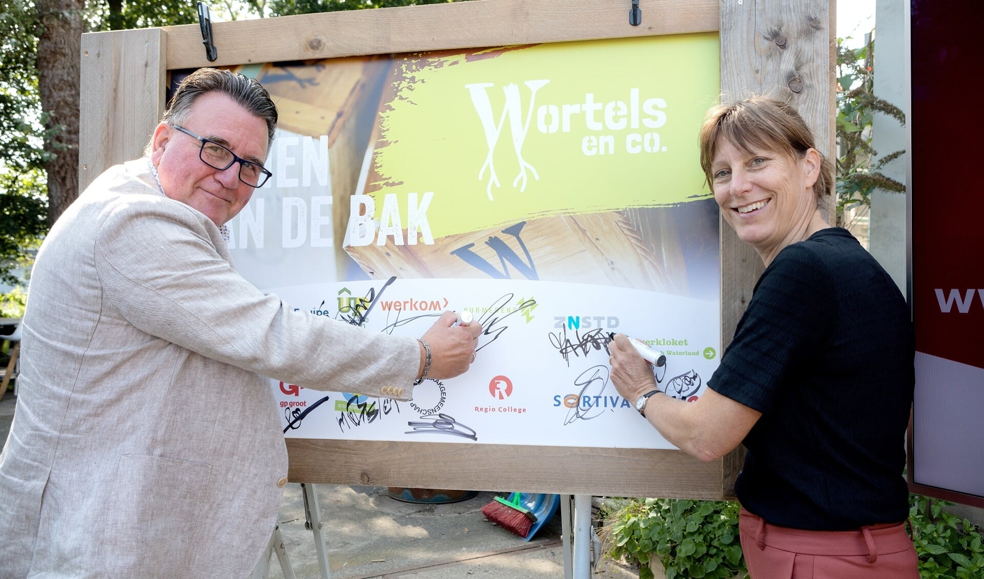 Wethouders Mario Hegger en Natasja Groothuismink verrichten de officiële opening van Wortels en co.