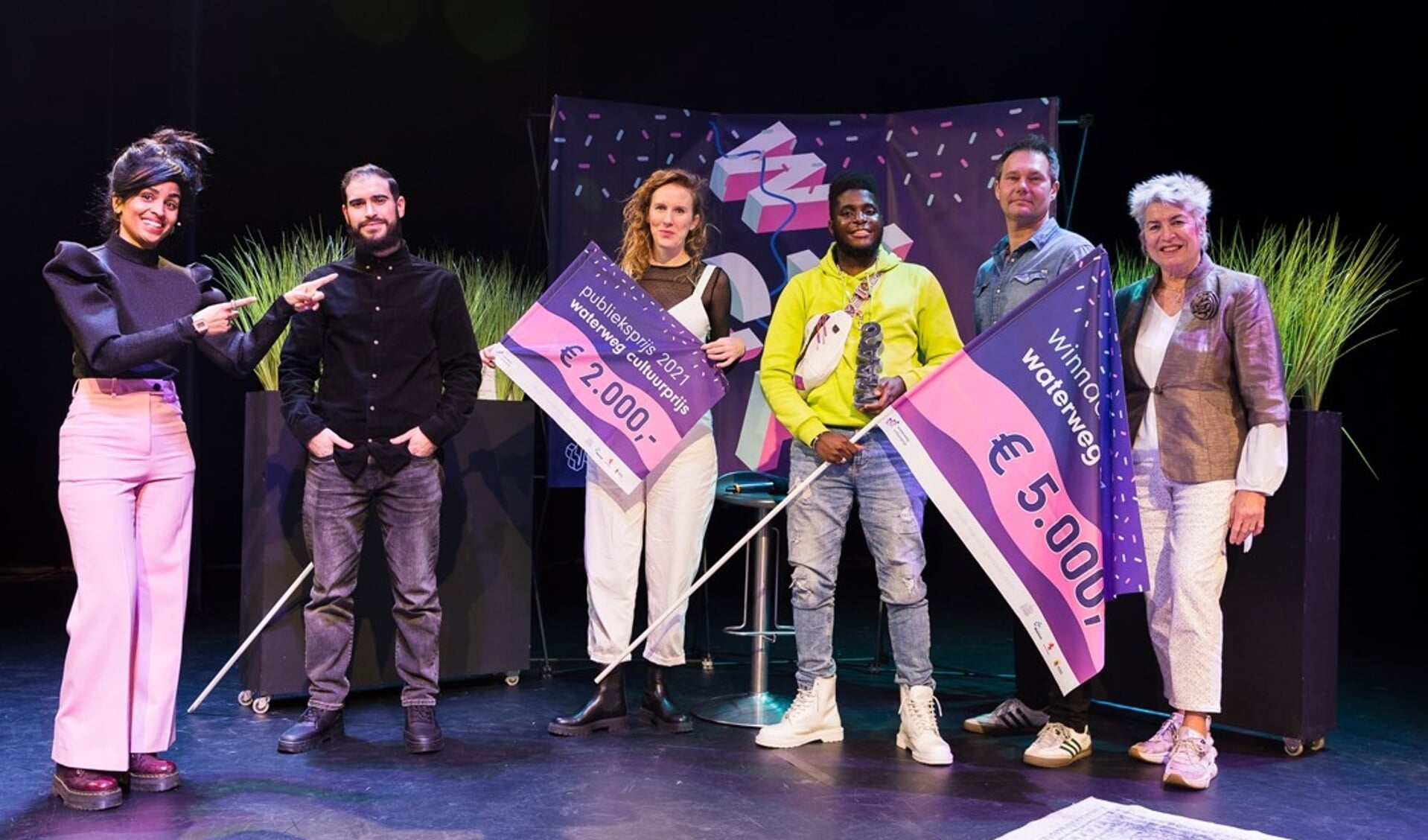 Groepsfoto van de winnaars van de Waterweg Cultuurprijs met Eugène Biffé met zijn project in Schiedam (gele trui). 