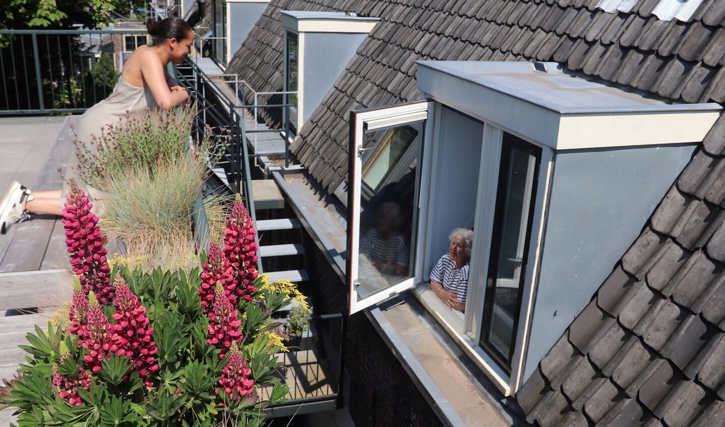 Rechts het Teylers Hofje met bewoonster Ingrid in haar ’nieuwe’ dakkapel. Op de voorgrond het balkon van buurvrouw Whitney.