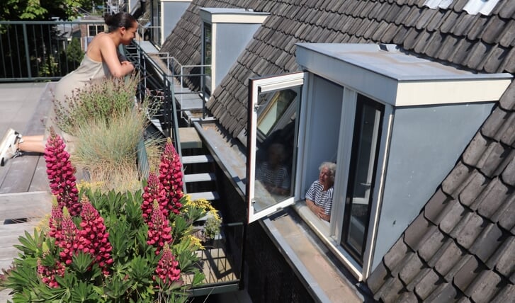 Rechts het Teylers Hofje met bewoonster Ingrid in haar ’nieuwe’ dakkapel. Op de voorgrond het balkon van buurvrouw Whitney.