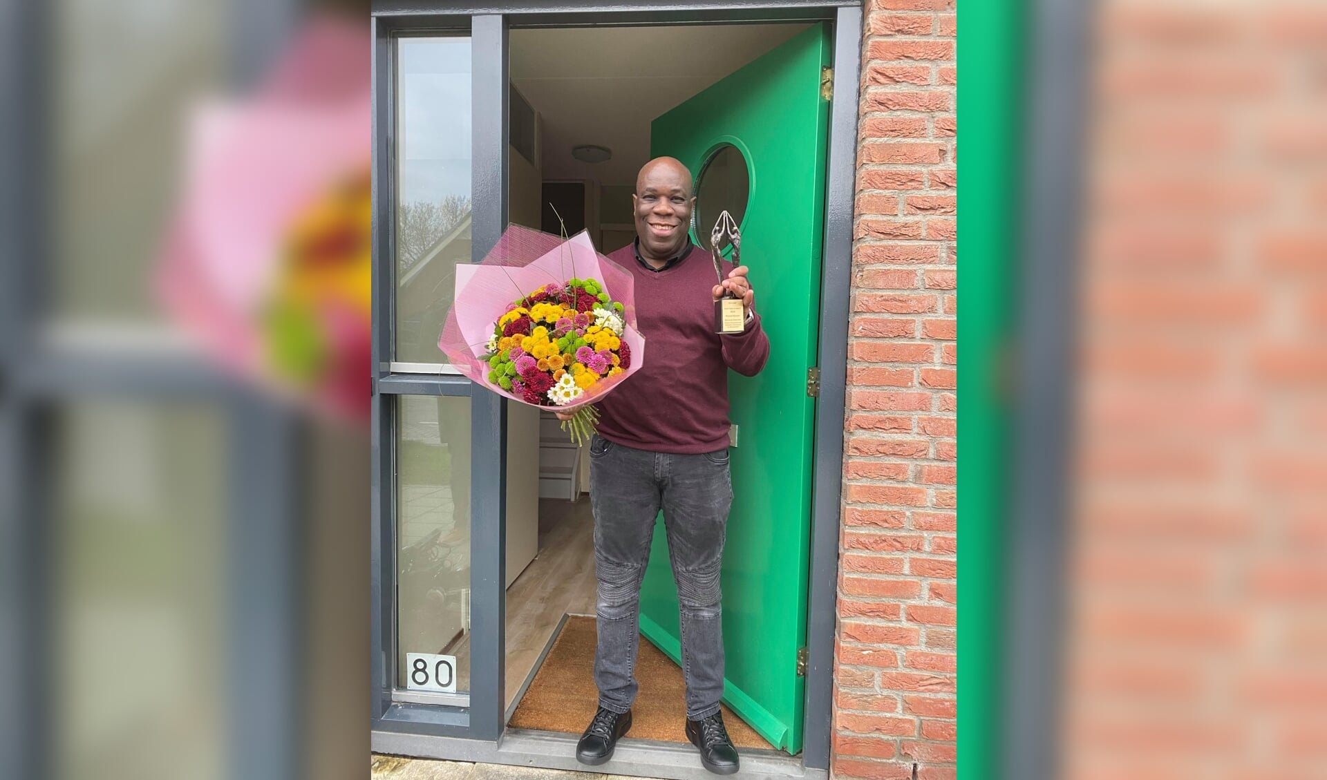 Ronald Bijnaar voor zijn voordeur, toen hij de Henk Nekrui Award met bloemen thuisbezorgd kreeg. 
