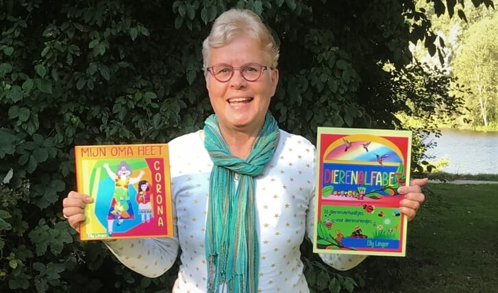 Elly Linger toont twee van haar kinderboeken.