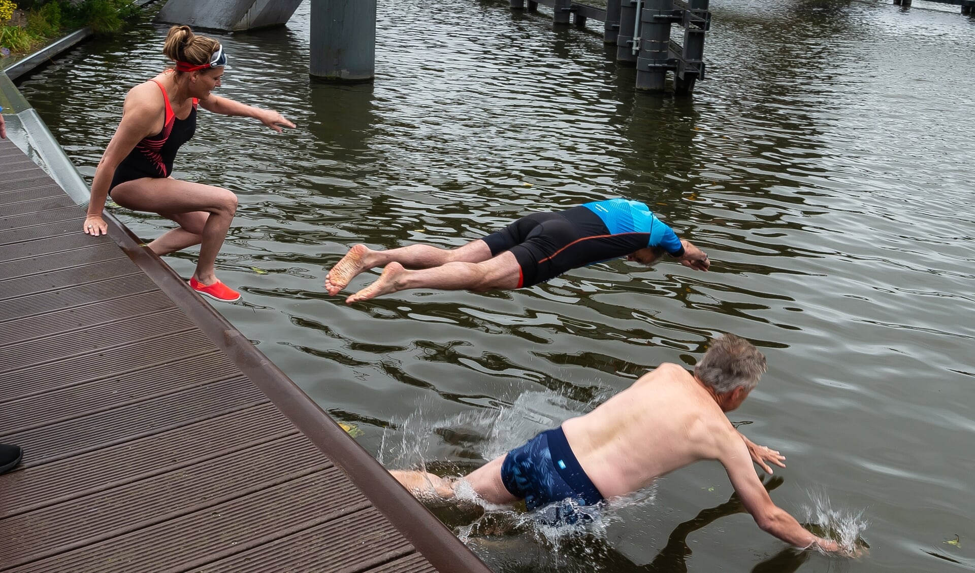 Swim to Fight Cancer werd in 2020 een groot succes. Hier plonzen v.l.n.r. Manja van der Weit, Spurd-directeur JanCor de Boer en burgemeester Don Bijl in het water van het Noordhollands Kanaal.
