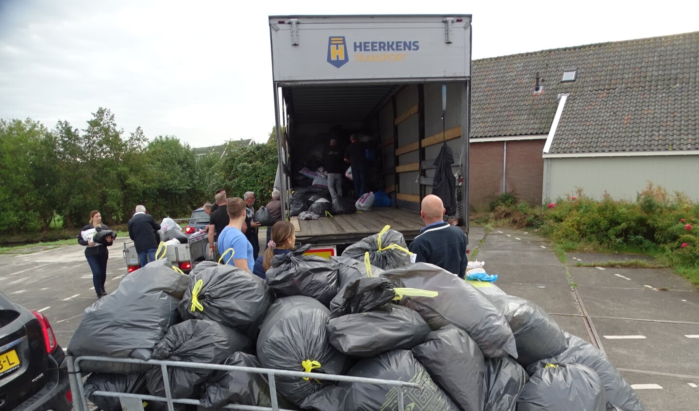Zakken vol kleding gaan in de vrachtwagen voor de actie 'Mensen in Nood'.