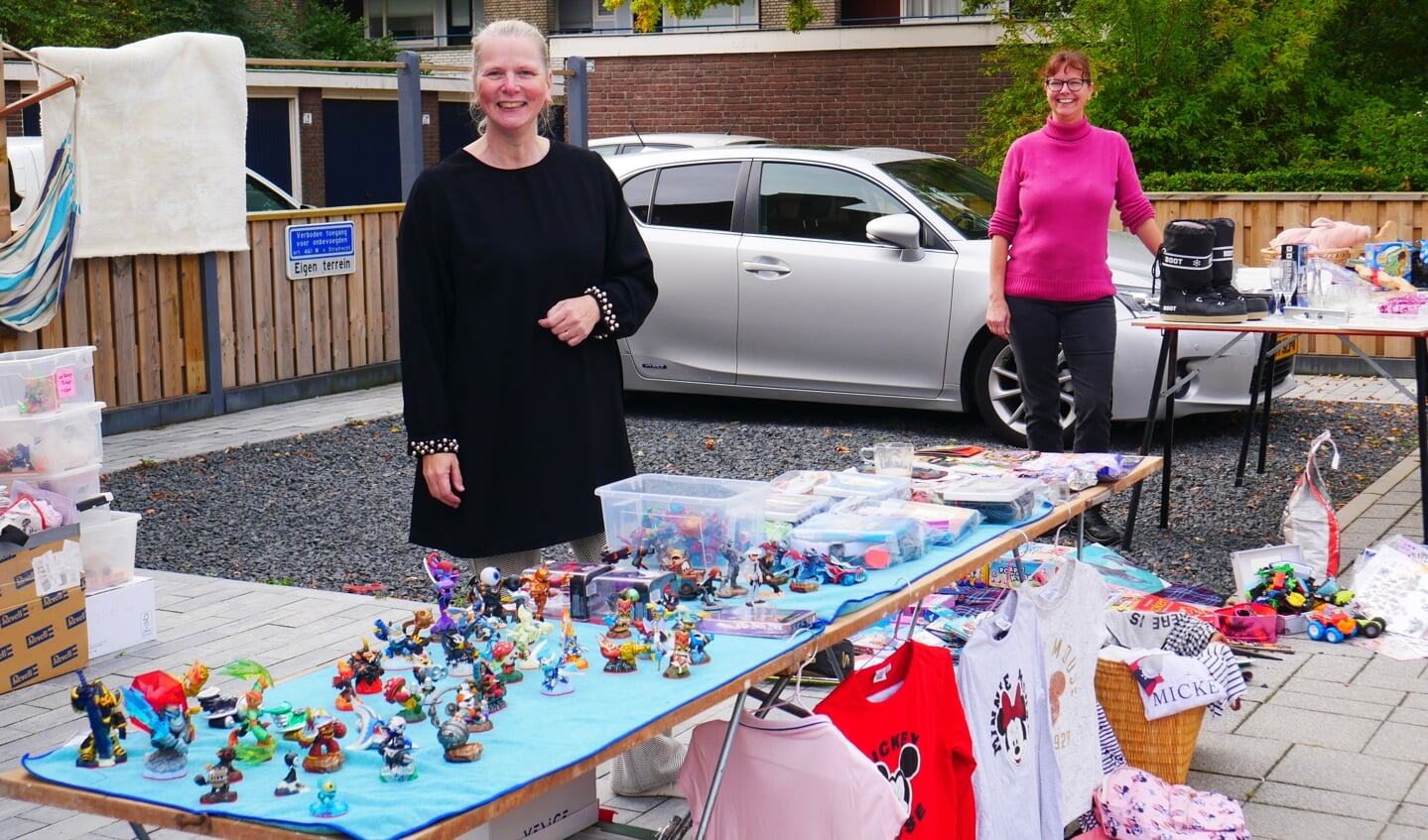 Shirley en Patricia staan met twee tafels voor het huis van Patricia.