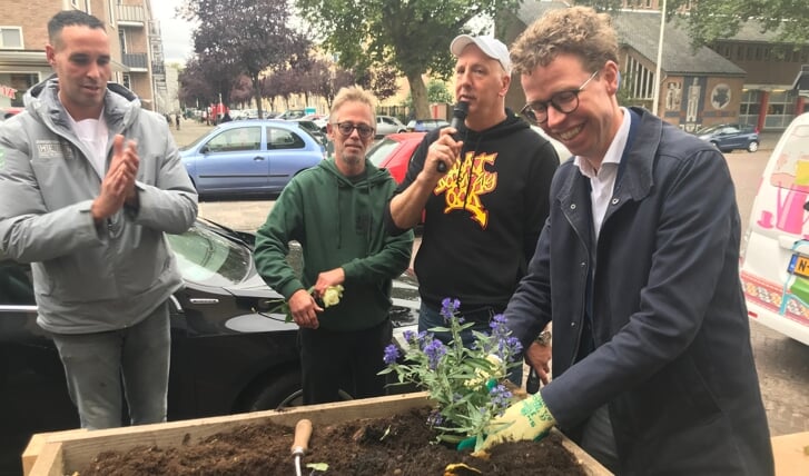 Stadsdeelwethouder Martijn Balster beplant de laatste bloembak.