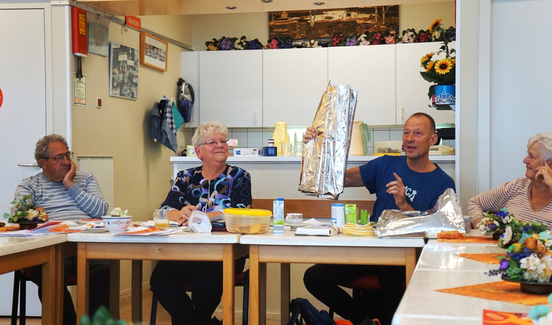 Willem Draaisma toont radiatorfolie tijdens de bijeenkomst over zuinig omgaan met energie.