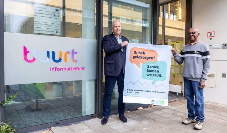 Wethouder Barend Rombout overhandigt de campagneposter aan Alwin Marengo, vrijwilliger Buurt Informatiepunt van Vitis Welzijn.