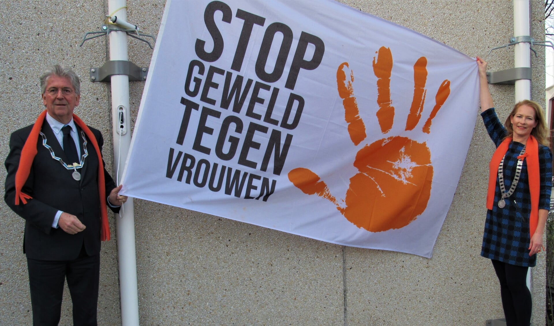 Burgemeester Edo Haan en Barbara Teuben, president Soroptimisten Club Beneden Maas vragen met het hijsen van de Orange the Worldvlag aandacht om geweld tegen vrouwen te stoppen.