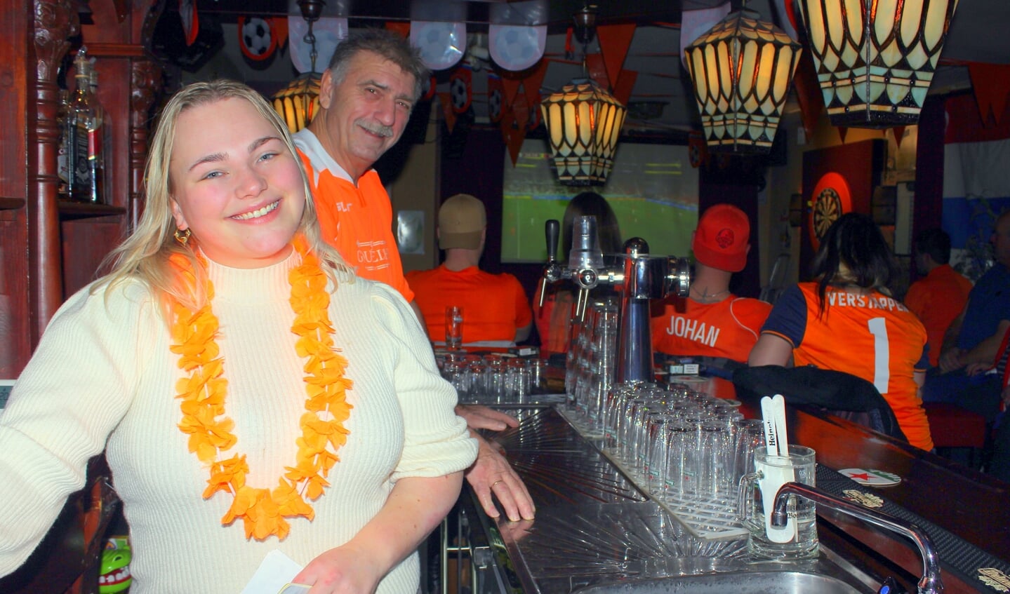 Bardame Zoë van Santen (23) met haar baas Johan van der Wilt (65) in Café Gouwezicht: 'Ik weet niets van voetbal, maar vind het wel gezellig zo met de gasten'.