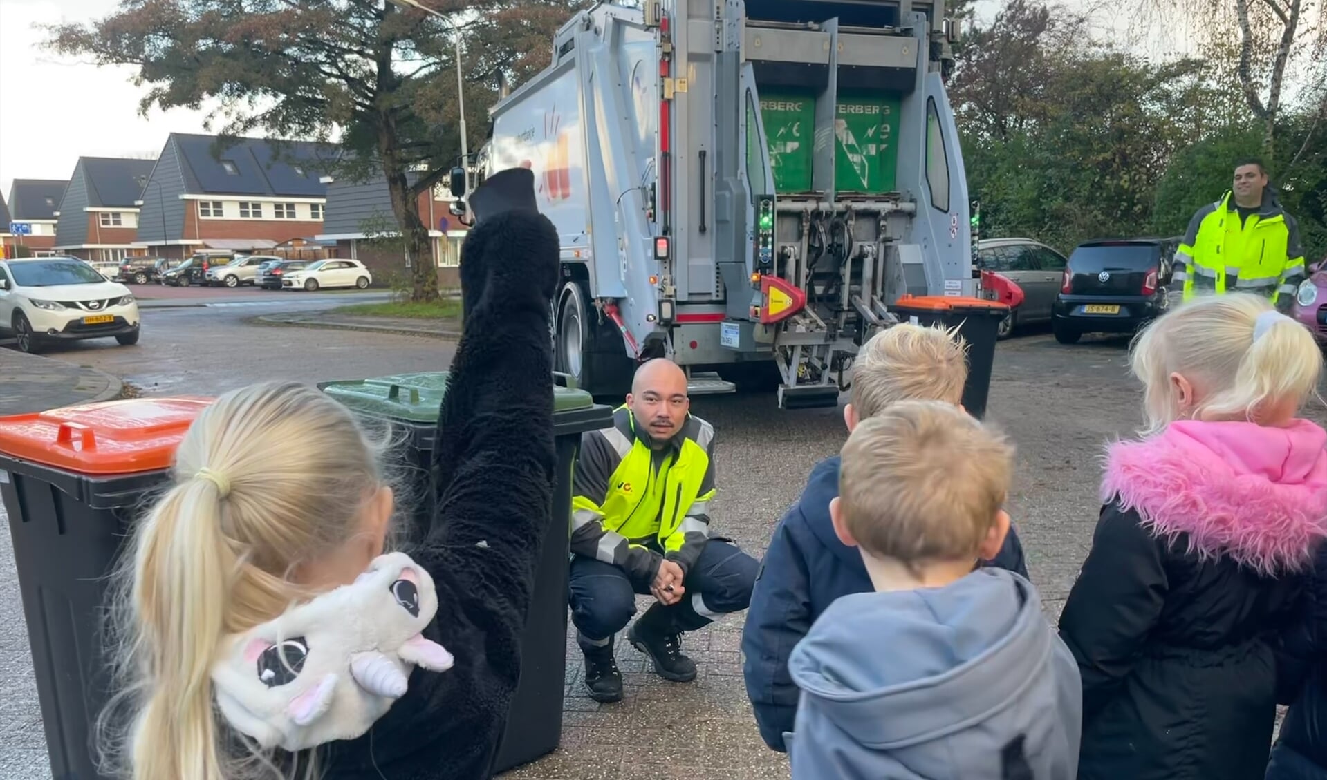Kinderen van IKC IJmond krijgen uitleg van chauffeurs over het gescheiden inzamelen van afval.