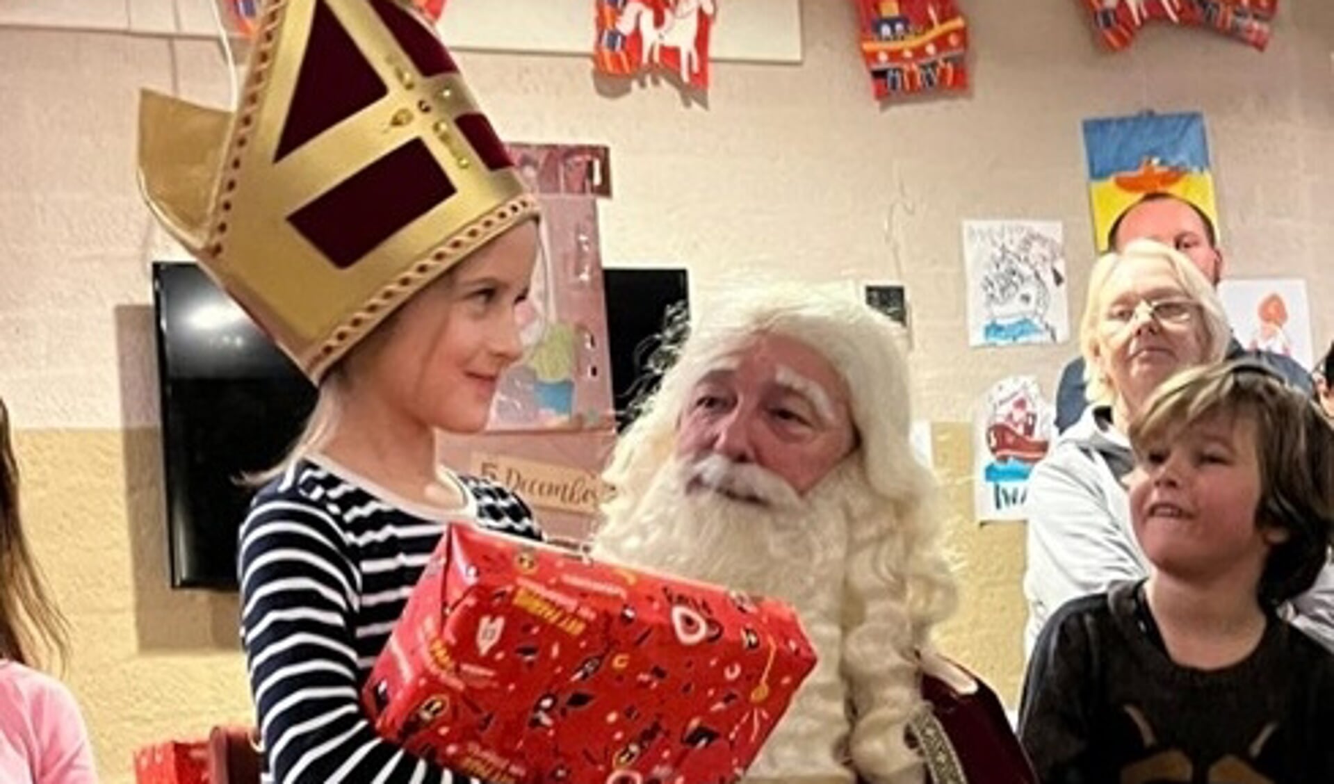 De blije koppies spraken boekdelen. Ook bij dit meisje dat voor even de mijter van Sinterklaas op mocht.