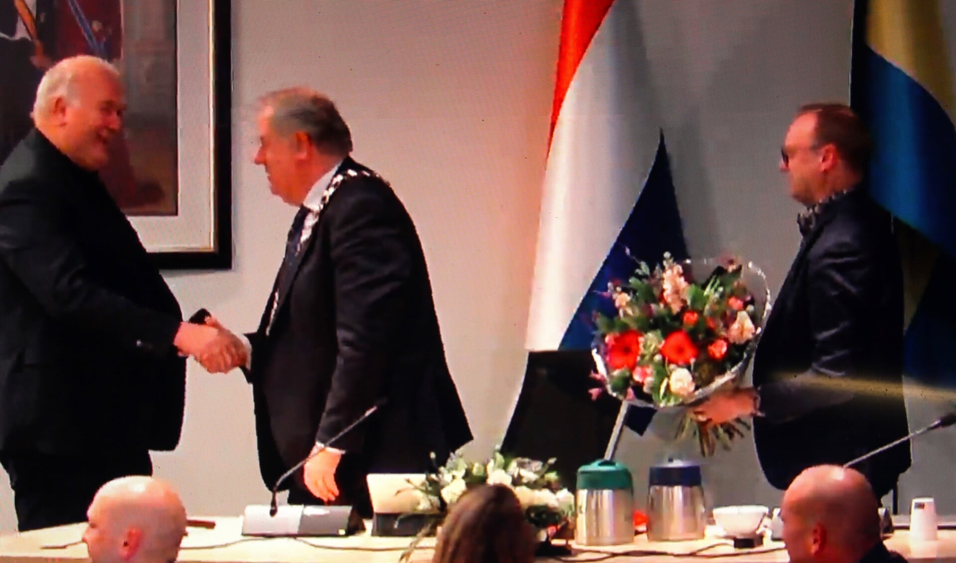 (Wnd.) burgemeester Bas Verkerk (tweede van links) schudt Ed Braam (BVR) de hand aan het einde van de laatste raadsvergadering die hij voorzat.