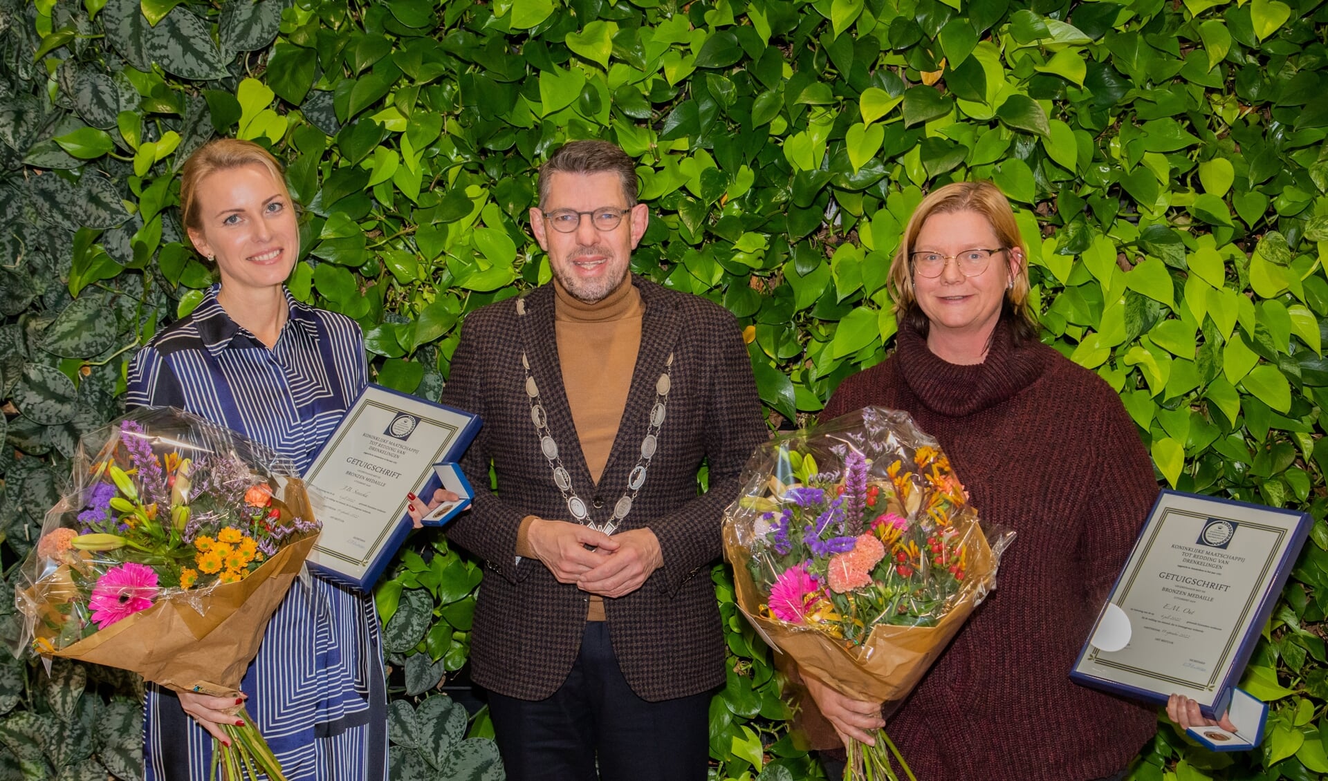 Joanna Senecka-van Adrichem (l.) en Esther Out ontvingen de penning en oorkonde van burgemeester Bouke Arends.